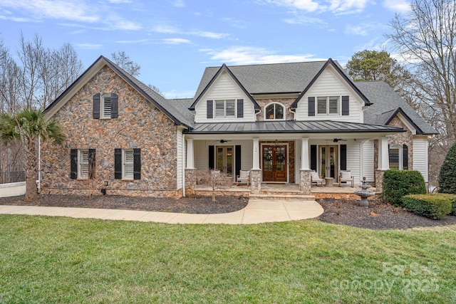 view of front facade with a ceiling fan, french doors, stone siding, and a standing seam roof