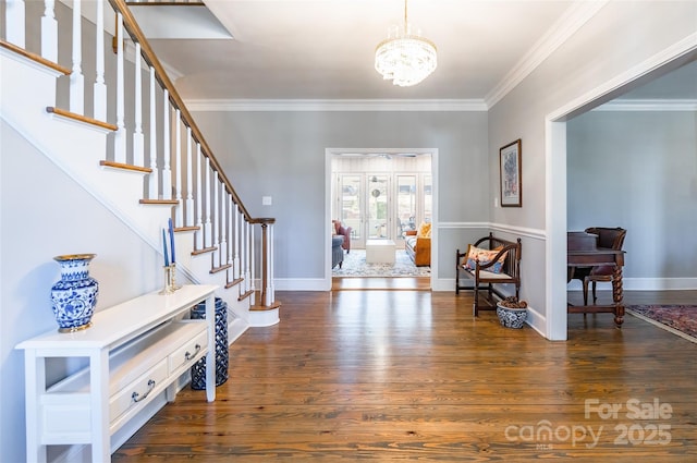 entryway featuring an inviting chandelier, ornamental molding, and dark hardwood / wood-style floors