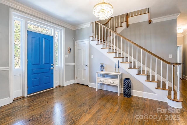 foyer featuring crown molding, dark wood-type flooring, and a chandelier