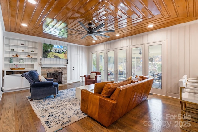 living room featuring hardwood / wood-style flooring, ornamental molding, built in features, and wooden ceiling