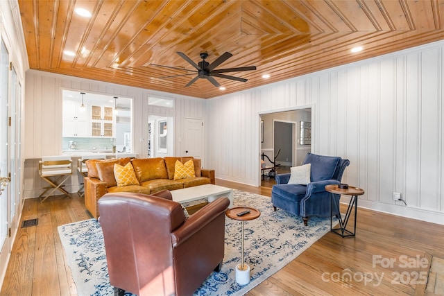 living room with crown molding, wooden ceiling, ceiling fan, and light hardwood / wood-style flooring