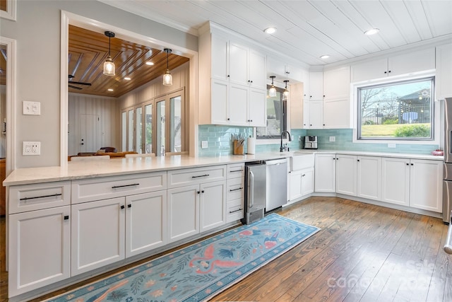 kitchen featuring tasteful backsplash, light hardwood / wood-style flooring, kitchen peninsula, and white cabinets