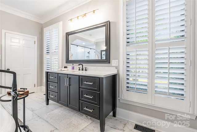 bathroom with vanity, a shower with shower door, and ornamental molding