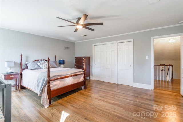 bedroom with hardwood / wood-style flooring, ceiling fan, crown molding, and a closet