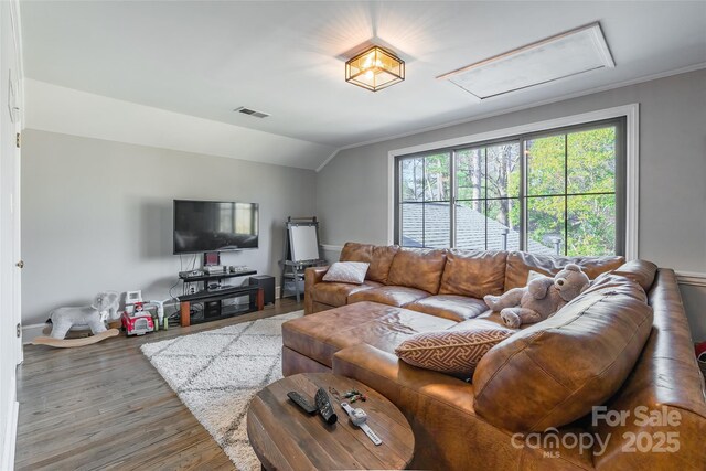 living room featuring crown molding, vaulted ceiling, and wood-type flooring