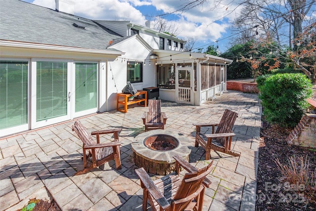 view of patio / terrace with french doors, a sunroom, and a fire pit