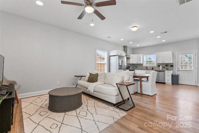 living area featuring recessed lighting, visible vents, and light wood-style floors