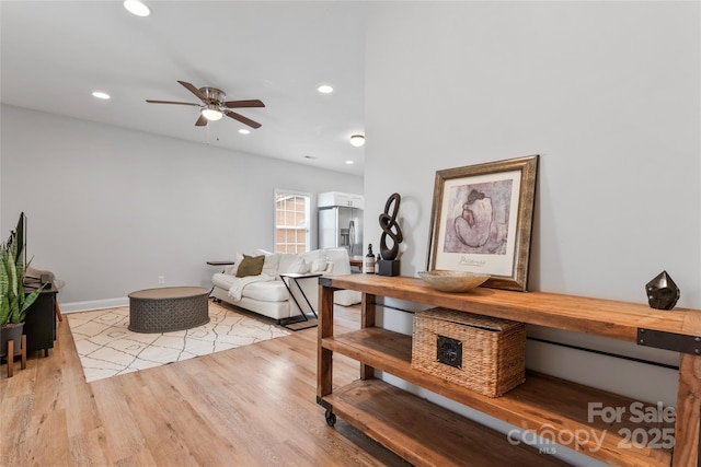 living area with a ceiling fan, recessed lighting, baseboards, and light wood finished floors