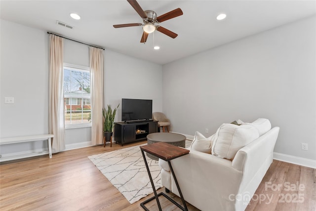 living room with baseboards, visible vents, ceiling fan, light wood-type flooring, and recessed lighting