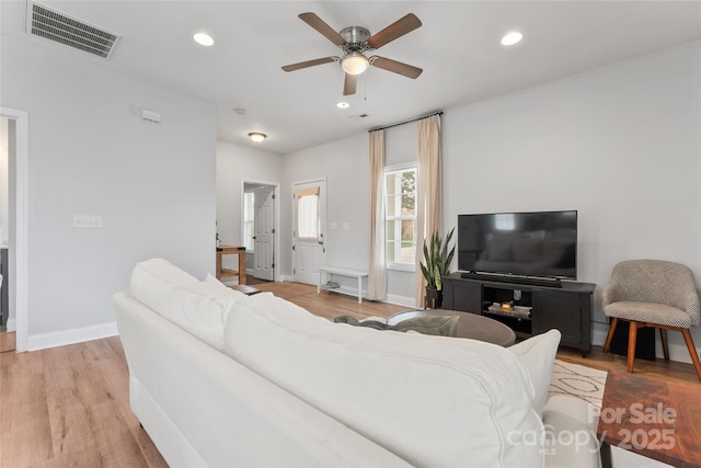 living area with light wood-type flooring, visible vents, and recessed lighting