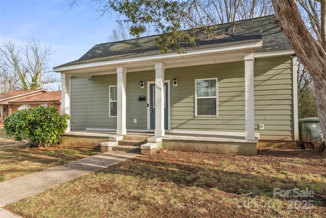 bungalow-style house with covered porch and roof with shingles