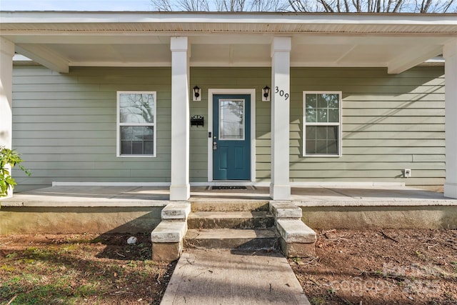 view of exterior entry featuring covered porch