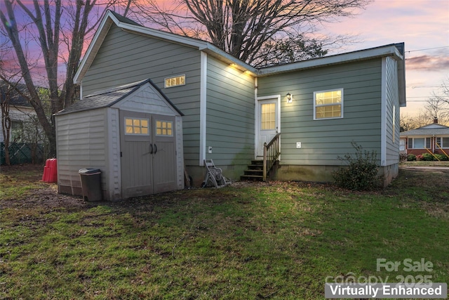 back of property at dusk featuring entry steps and a yard