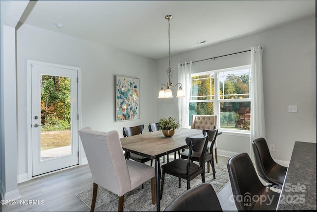 dining room featuring an inviting chandelier and light hardwood / wood-style flooring