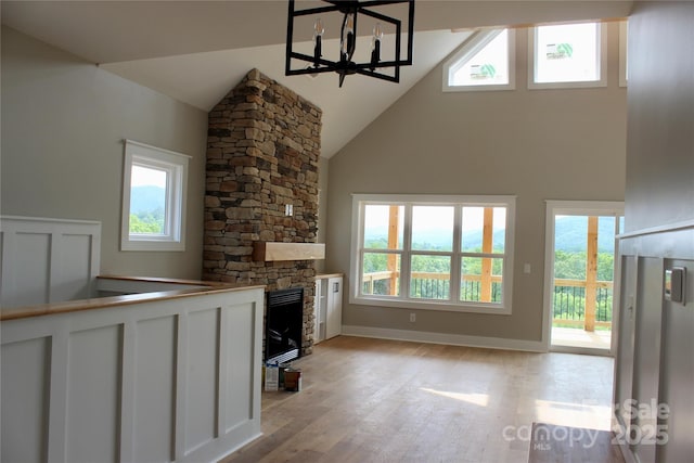 122 Chepstow Pl, Black Mountain, NC 28711 - unfurnished living room featuring high vaulted ceiling, light wood finished floors, plenty of natural light, and a chandelier