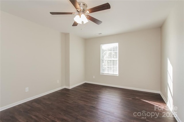 spare room featuring dark wood-type flooring and ceiling fan