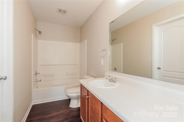 full bathroom featuring vanity, bathing tub / shower combination, hardwood / wood-style floors, and toilet