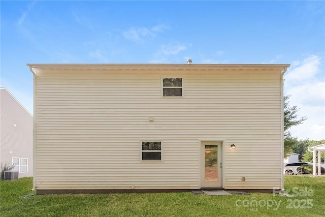 rear view of house featuring a yard and central air condition unit