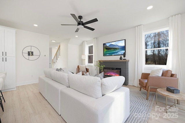 living room with ceiling fan and light hardwood / wood-style floors