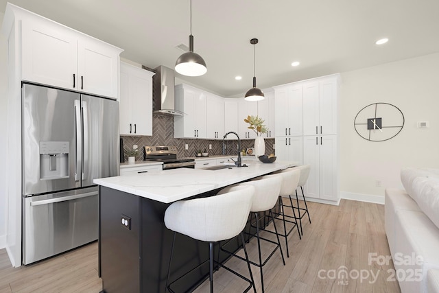 kitchen with white cabinetry, wall chimney range hood, sink, and appliances with stainless steel finishes