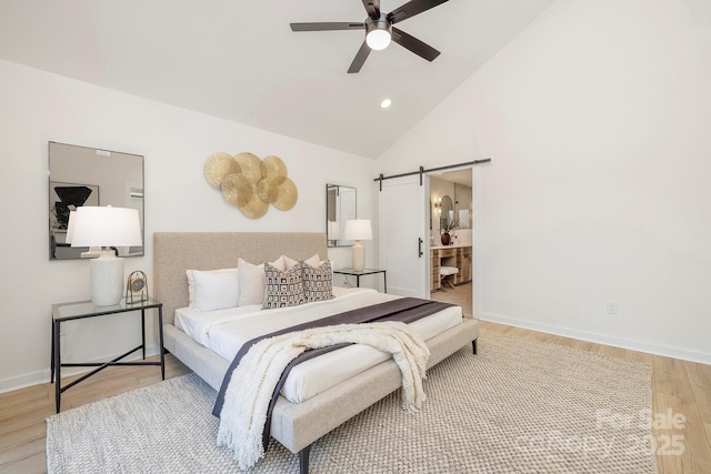 bedroom featuring high vaulted ceiling, a barn door, hardwood / wood-style floors, and ceiling fan