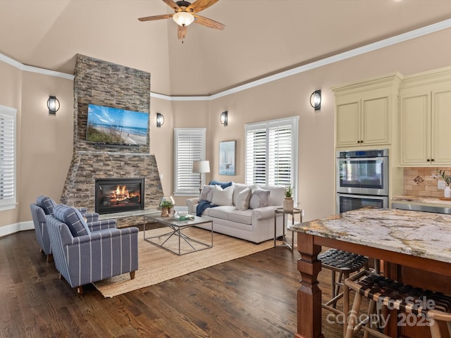 living room featuring crown molding, a stone fireplace, dark hardwood / wood-style floors, and ceiling fan