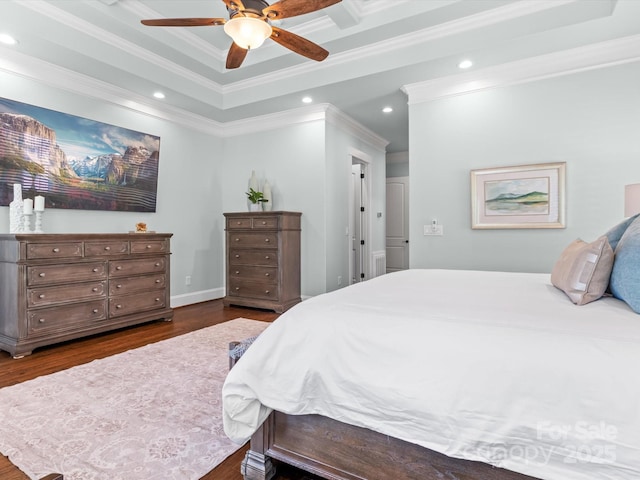 bedroom featuring dark wood-type flooring, ornamental molding, a raised ceiling, and ceiling fan