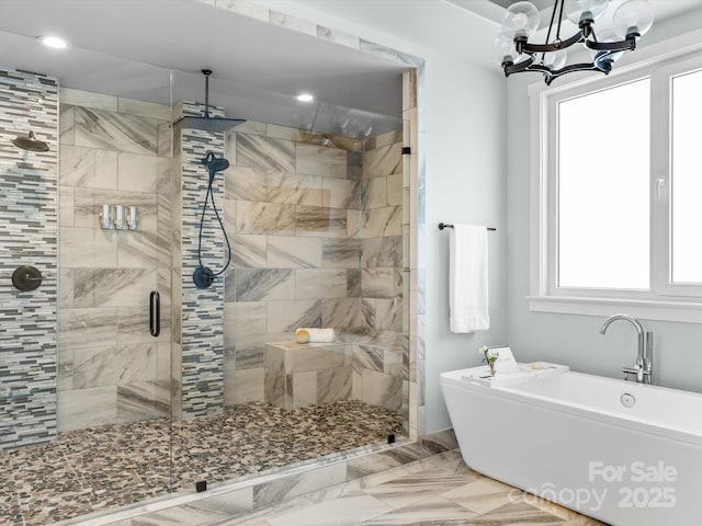 full bathroom featuring a chandelier, a freestanding bath, and a shower stall