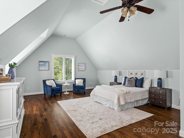 bedroom featuring baseboards, vaulted ceiling with skylight, a ceiling fan, and dark wood-type flooring