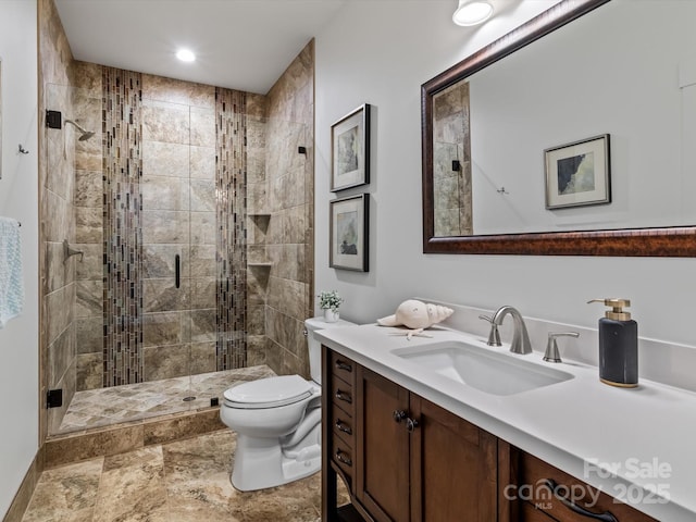 bathroom featuring toilet, vanity, and walk in shower