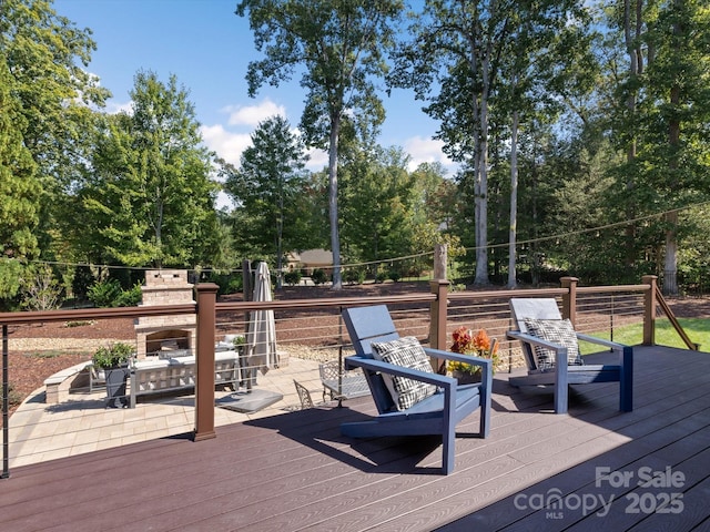 wooden deck featuring an outdoor stone fireplace