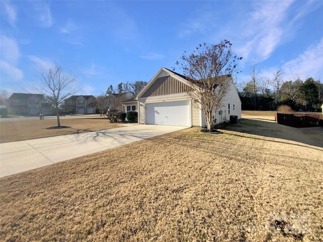 view of front of house with central AC unit, a garage, and a front yard