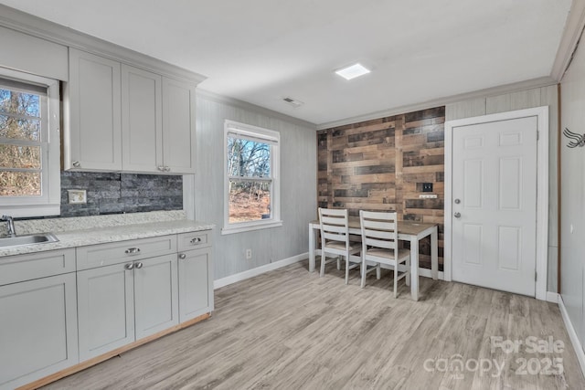 kitchen featuring sink, ornamental molding, light hardwood / wood-style floors, and gray cabinets