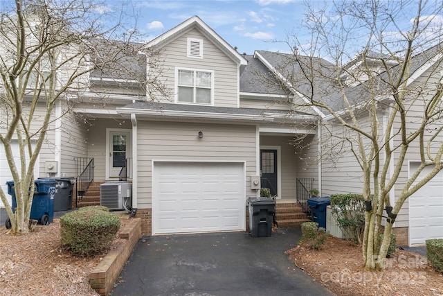 front of property with a garage and central air condition unit