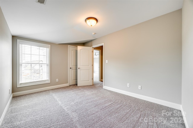 unfurnished bedroom featuring light colored carpet and baseboards