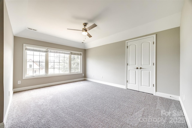 unfurnished bedroom with visible vents, baseboards, ceiling fan, carpet, and a closet