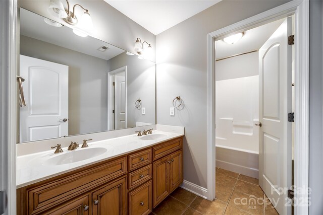 bathroom with double vanity, visible vents, a sink, and tile patterned floors