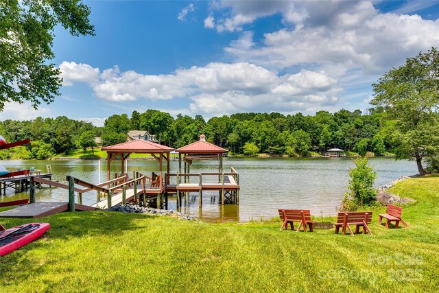 dock area featuring a water view, a gazebo, and a yard