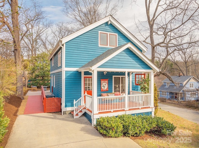 bungalow-style home featuring covered porch and roof with shingles