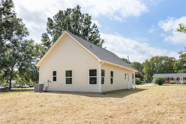 view of side of property featuring a yard and central air condition unit