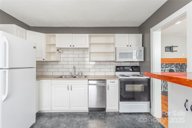 kitchen with white appliances, white cabinets, light countertops, open shelves, and a sink