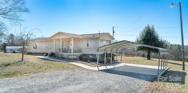 view of front facade featuring a carport, covered porch, and a front yard