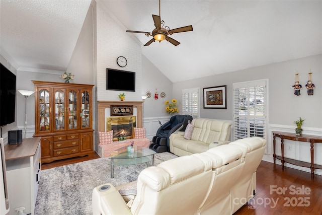 living room featuring ceiling fan, high vaulted ceiling, dark hardwood / wood-style floors, and a fireplace