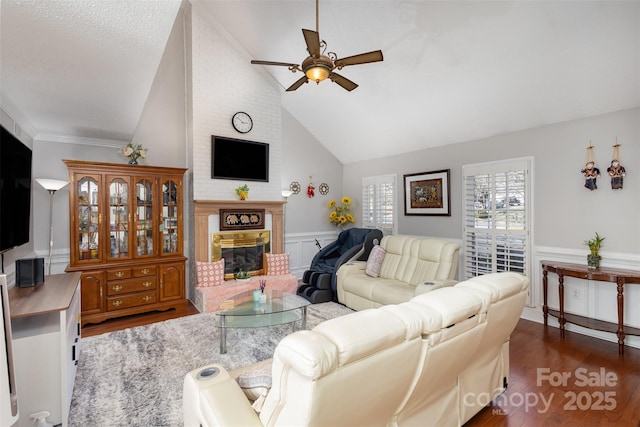 living room featuring a fireplace, high vaulted ceiling, dark hardwood / wood-style floors, and ceiling fan