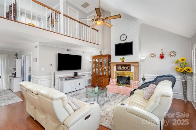 living room with dark hardwood / wood-style flooring, a fireplace, high vaulted ceiling, and ceiling fan