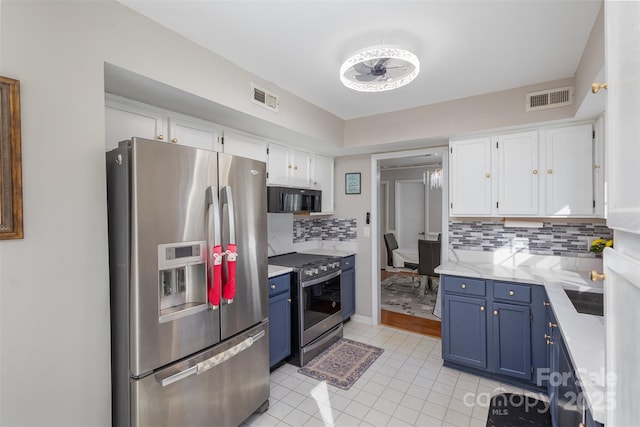 kitchen with blue cabinetry, tasteful backsplash, light tile patterned floors, stainless steel appliances, and white cabinets