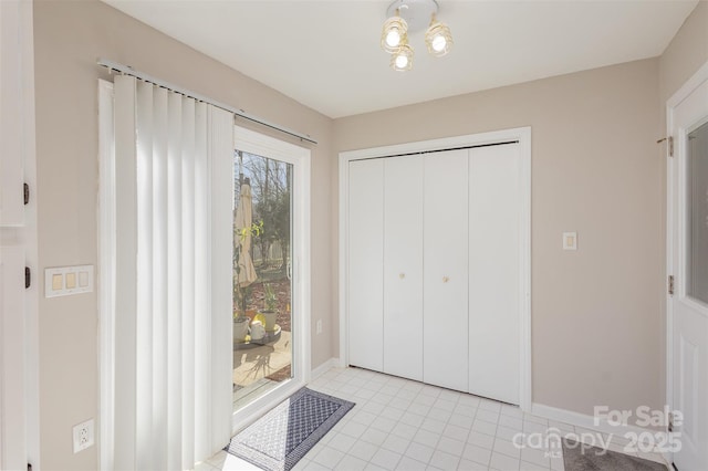 interior space featuring light tile patterned flooring, access to outside, and a closet