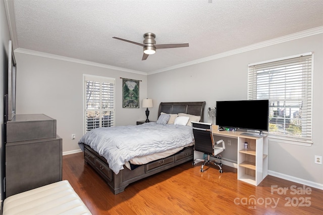 bedroom featuring ceiling fan, crown molding, wood-type flooring, and a textured ceiling