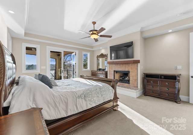 carpeted bedroom featuring crown molding, access to outside, ceiling fan, and a fireplace