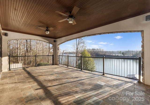 deck with a water view and ceiling fan